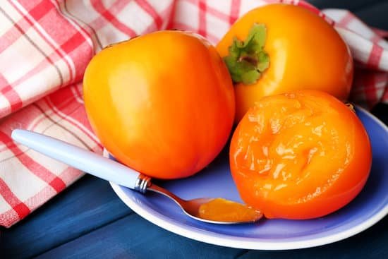 canva ripe persimmons on color wooden background MAD L8omeJM