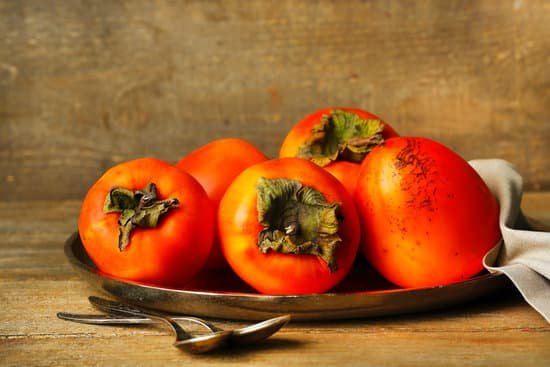 canva ripe sweet persimmons on wooden table MAD L664C6k