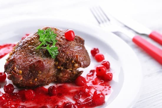 canva roasted meat with cranberry sauce on plate MAD McghCc8