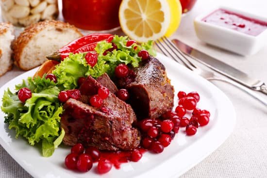 canva roasted meat with cranberry sauce on plate on table MAD MRMzZb8