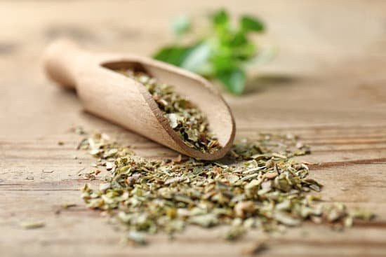 canva scoop with aromatic dried oregano on wooden background MAD9T