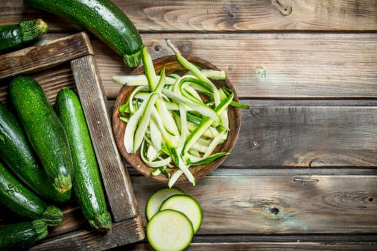 canva sliced and whole zucchinis on a wooden table MAEP2sOYb9s