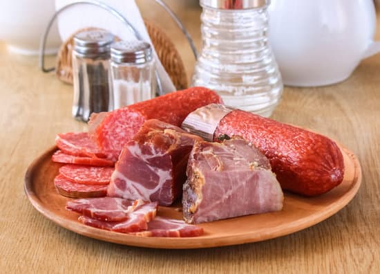 canva slices of meat and sausages on a plate MAEQQY3y40c