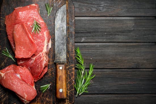 canva slices of meat rosemary and knife on a wooden board MAEP4EzwfG4