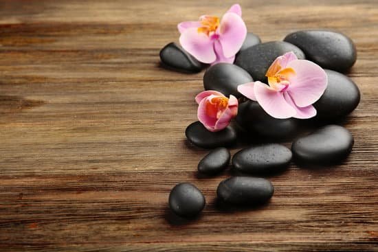 canva spa stones and orchid flowers on wooden background MAD Qmm6fNg