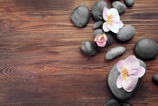 canva spa stones and orchid flowers on wooden table top view MAD QnQjDG4