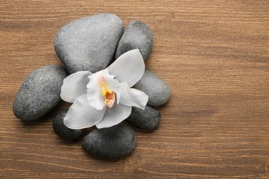 canva stones and white orchid on wooden background MAD Qv9D26Q