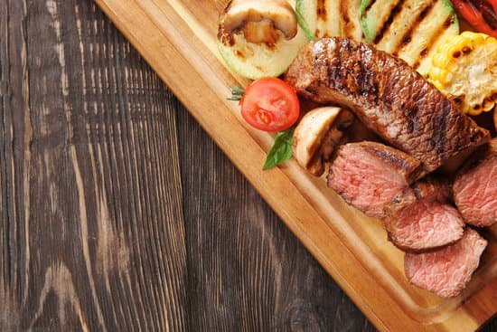 canva tasty juicy grilled meat with vegetables on wooden board MAD9T3IYGWE