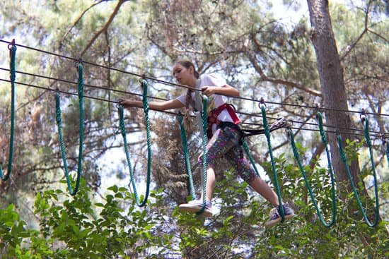 canva teenager climbing in hanging ropes in rope amusement park MAD7DGoq4eg