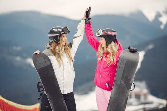 canva two happy women with snowboards doing high five outdoors MAEWQIGuCTQ