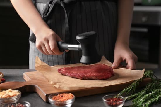 canva woman beating raw steak with meat mallet in kitchen MAD9T9zYmf0