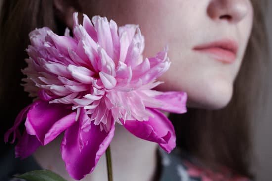 canva woman holding a pink peony