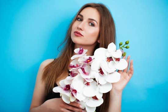 canva woman holding an orchid on blue background MAEAsgB27Cw