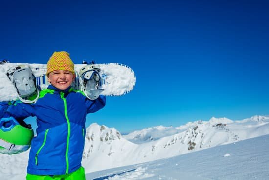 canva young boy holding a snowboard in the mountain slopes MAD gWuLRKo