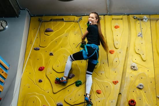 canva young woman climbing a tall indoor man made rock climbing wall MAD bRpeLHs
