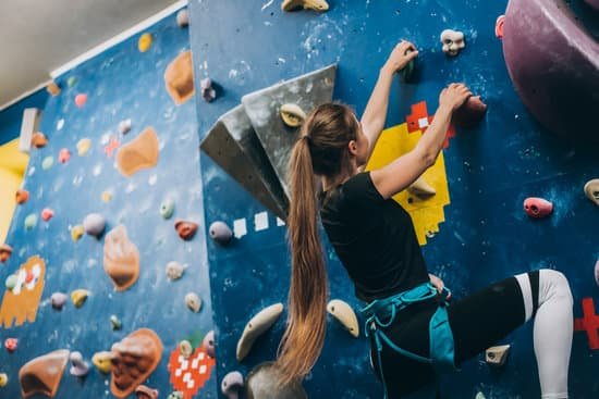 canva young woman climbing a tall indoor man made rock climbing wall MAEABnLBecM