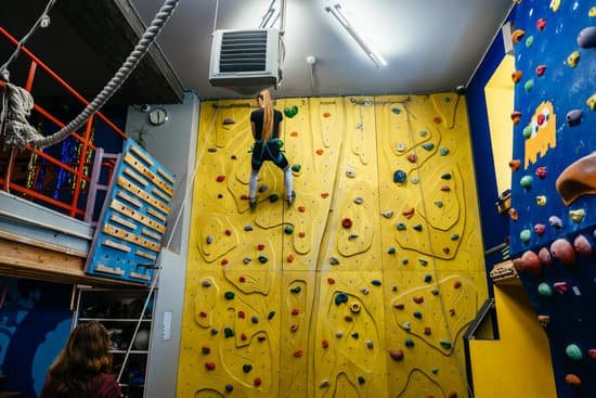 canva young woman climbing a tall indoor man made rock climbing wall MAEBccQVYHE