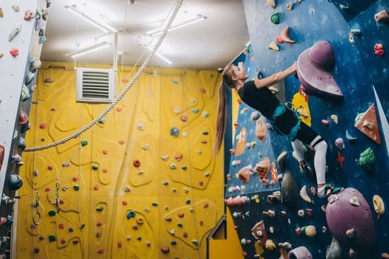 canva young woman climbing an indoor rock climbing wall MAD bb6JGqc