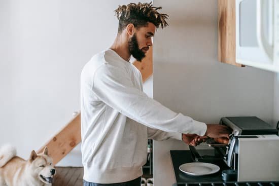 canva bearded young black man heating croissant in microwave oven standing near dog MAEMMNkntpk