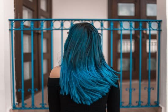 canva blue haired woman facing metal fence MADlI0ZfQ04