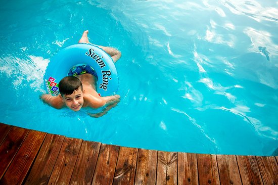 canva boy floating in pool with water ring MADGv24WC8Q