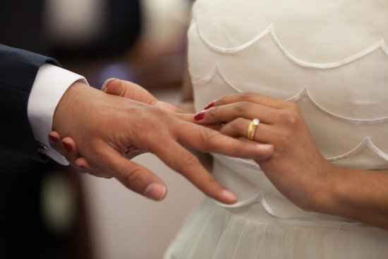 canva bride putting a ring on grooms hand MADGx