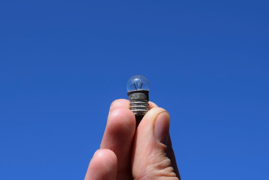 canva bulb on 3 volts in a hand against the sky MADHn1qE3jw