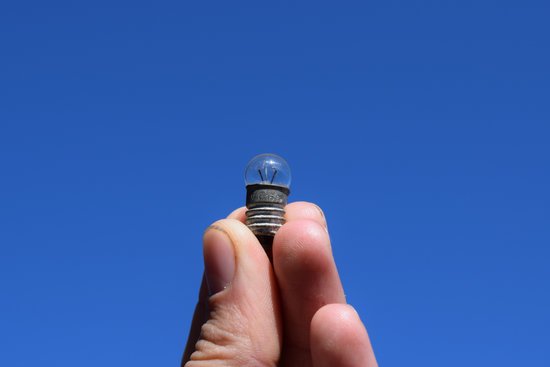 canva bulb on 3 volts in a hand against the sky MADJiM3lfT4