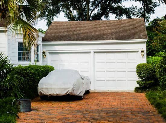 canva car covered on brick driveway with white two car garage MADaqQGr FY