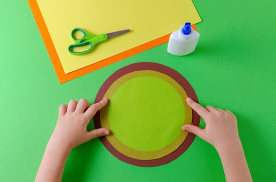 canva child glues two circles with color paper glue and scissors MADNnLbn5YE