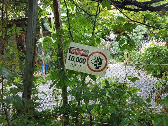 canva danger 10000 volts sign on metal fence MAC41qqT