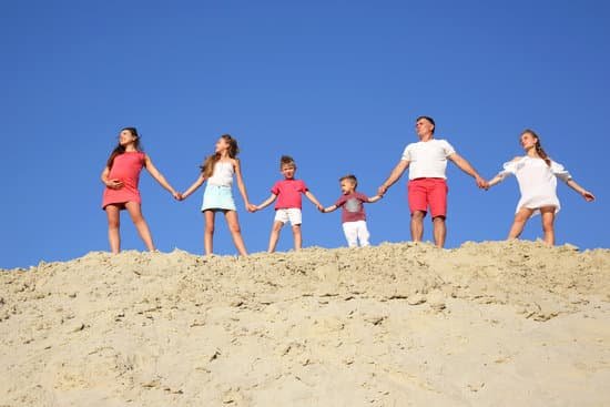 canva family with children stands holding hands on a sandy hill MADYOKW37sw