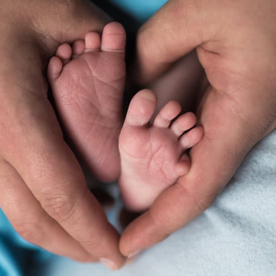 canva feet of a newborn child in the hands of parents. parental care parental love MADzpItvASQ