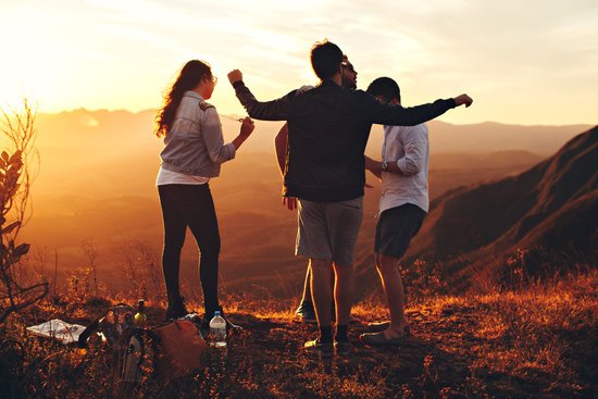 canva four person standing at top of grassy mountain
