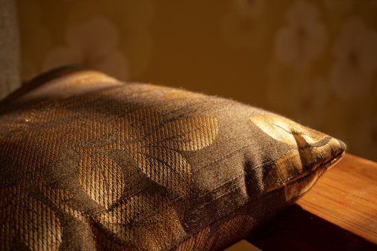 canva gold pillow on brown wooden surface