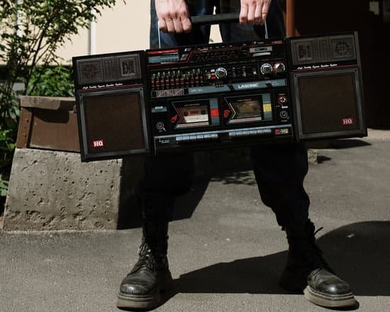 canva man in black leather boots holding black and red radio MAECvAjPDOc