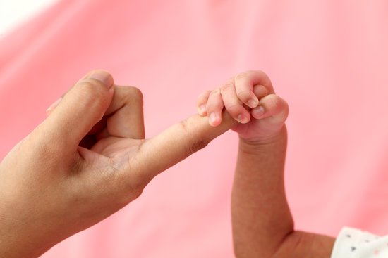 canva newborn holding parents finger