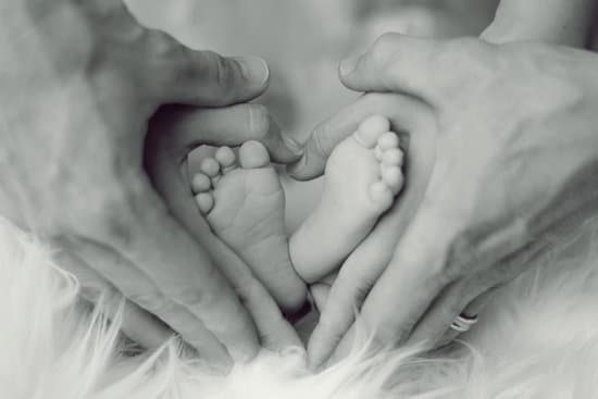 canva parents hands holding baby feet MADQ5AVs Nk