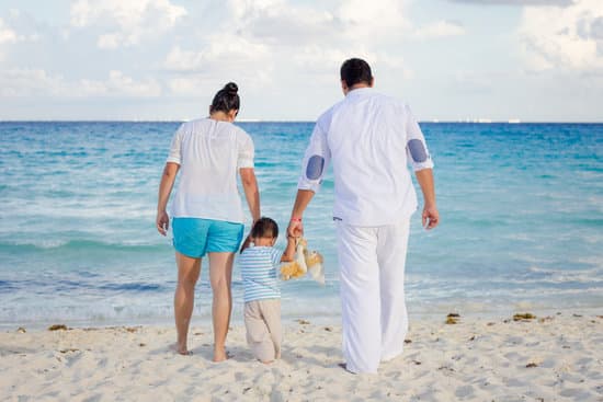 canva parents with a kid on the beach MADQtj1RfJk