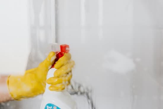 canva person in glove spraying detergent at walk in shower glass MAD PLfiNF0
