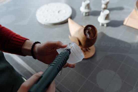 canva person putting glue on the dome plastic piece from a glue gun MAEZIKmHYbM