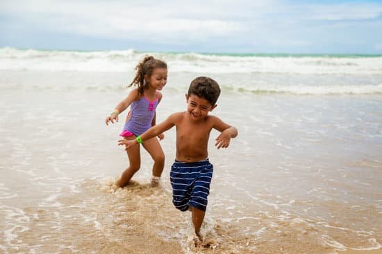 canva photo of children smiling while running on seashore MADyRKsjYLE