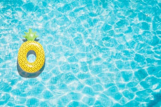 canva pineapple pool float ring floating in a refreshing blue swimming pool MADatX7edww