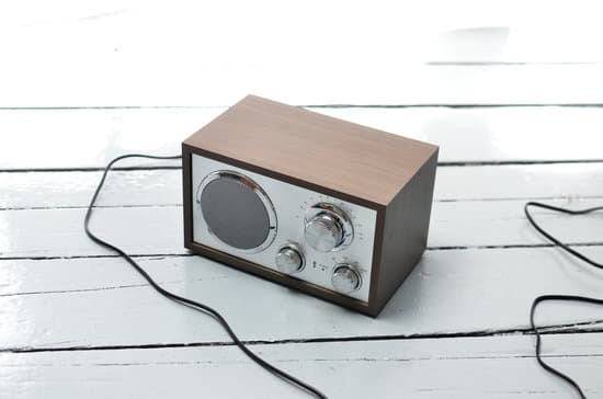 canva retro radio with metal front placed on wooden table MAESCLhcBAg