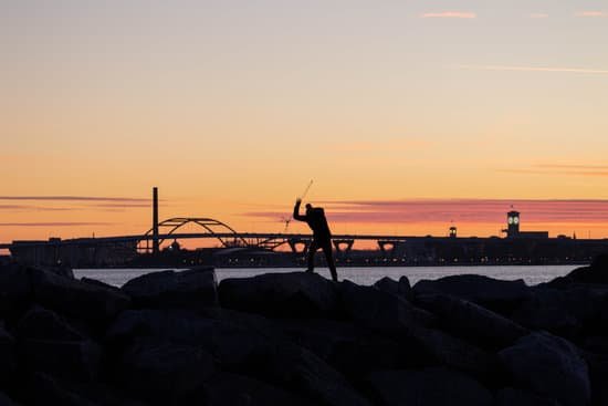 canva silhouette of person standing on rocks under orange sky MADTkagAJmE