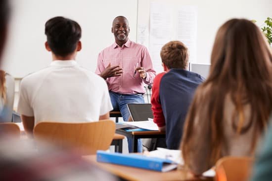 canva teacher standing at front of college students for lesson MACowUsCeNQ