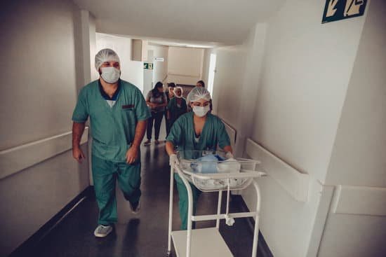 canva unrecognizable obstetrician and nurse carrying newborn baby trolley in hospital MAEDWkL1fl4