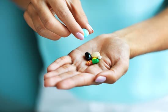 canva vitamins and supplements. female hand holding colorful pills MADauSnOfQQ