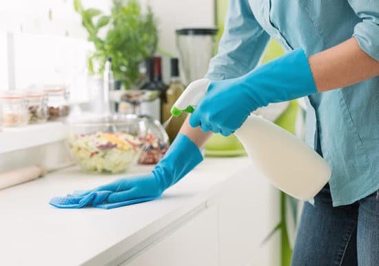 canva woman cleaning with a spray detergent