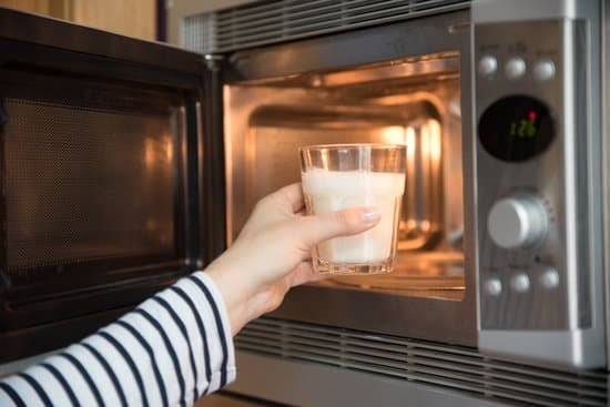 canva woman warming a glass of milk in the microwave MAC4FP5hbOY